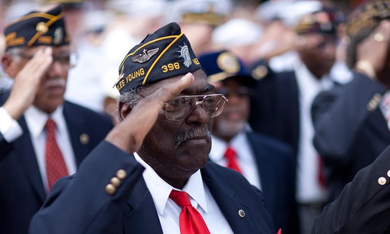 This is a photograph of an American military veteran saluting the American flag. 