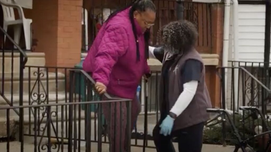 This is a screenshot from a UPenn YouTube video showing a physical therapist working with an older adult patient.