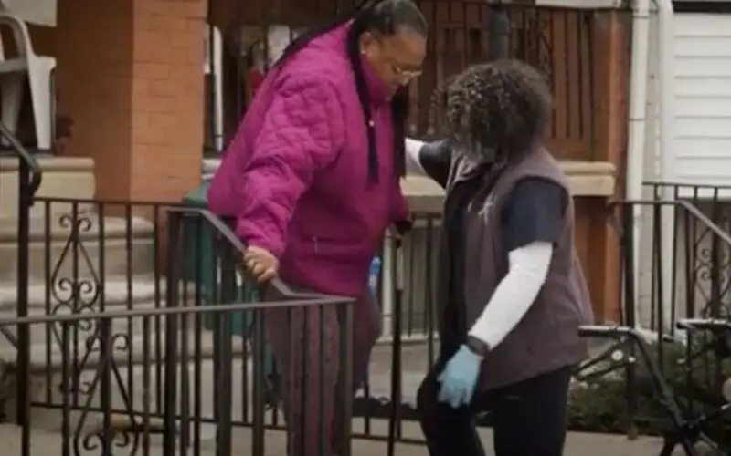 This is a screenshot from a UPenn YouTube video showing a physical therapist working with an older adult patient.