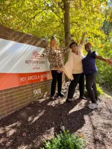 This is an external photograph of staff standing in front of the Autumn Lake Healthcare at Arcola sign, a Montgomery County nursing home in Silver Spring. 