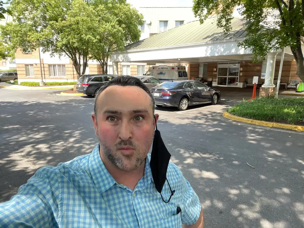 This is a photograph of Ryan Miner, of The Senior Soup, standing in front of Bedford Court Healthcare Center in Silver Spring, Maryland. 